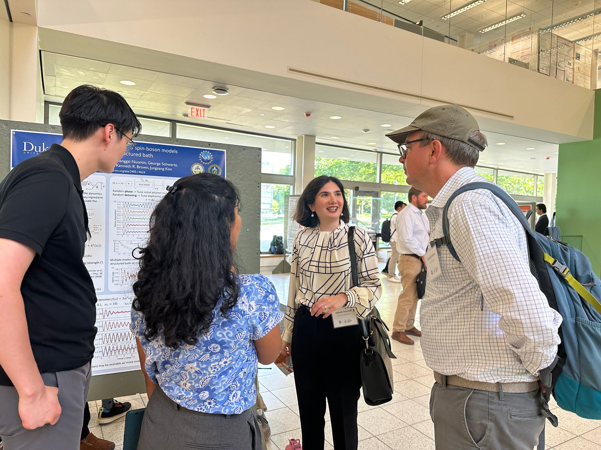 Zohreh Davoudi and Ken Brown talking to graduate students during the poster session at the 2024 RQS Annual Workshop