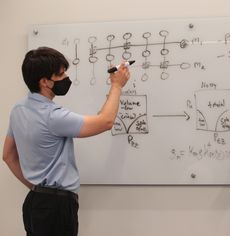 Michael Gullans draws a diagram on a white board.