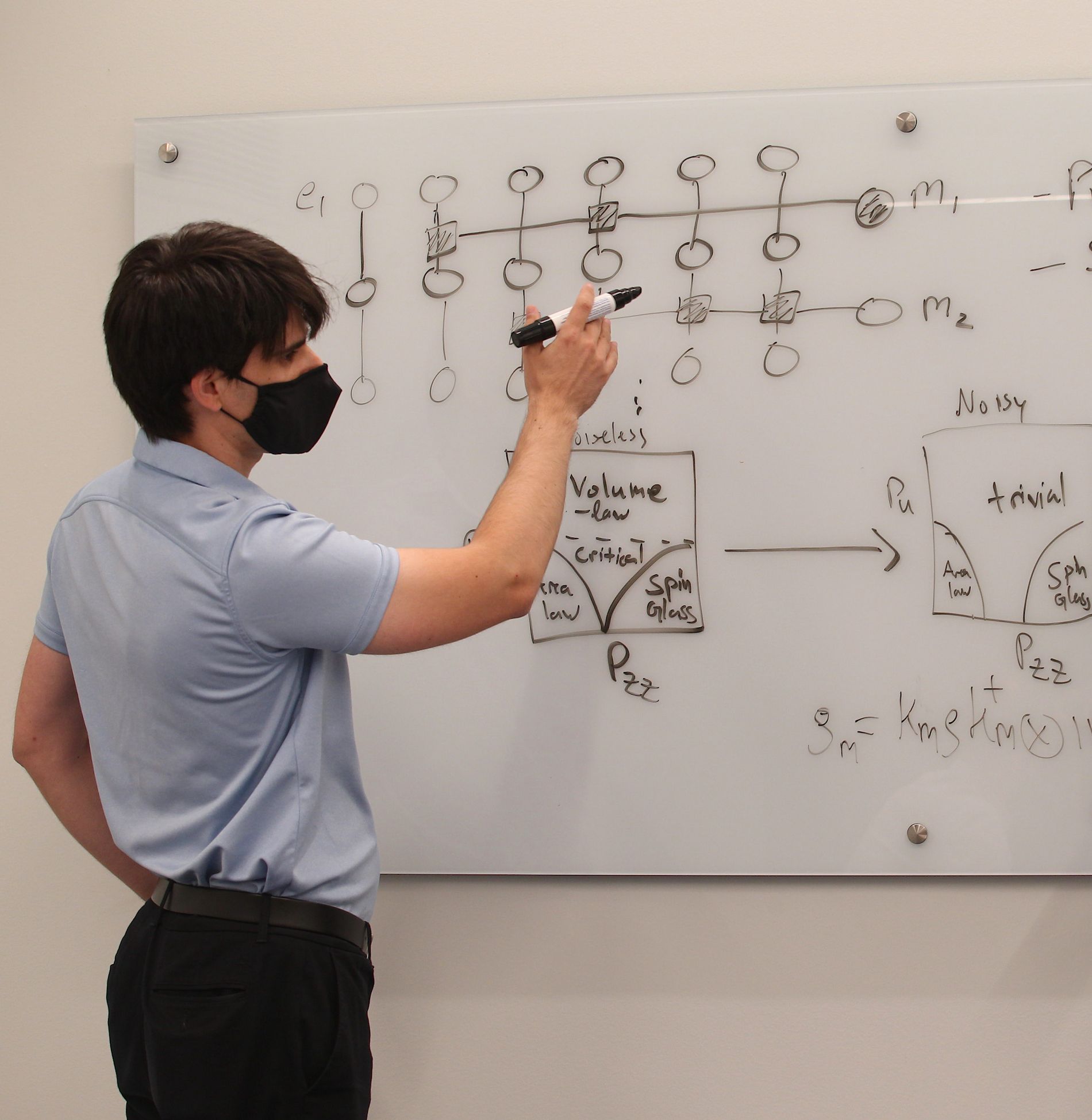 Michael Gullans draws a diagram on a white board.