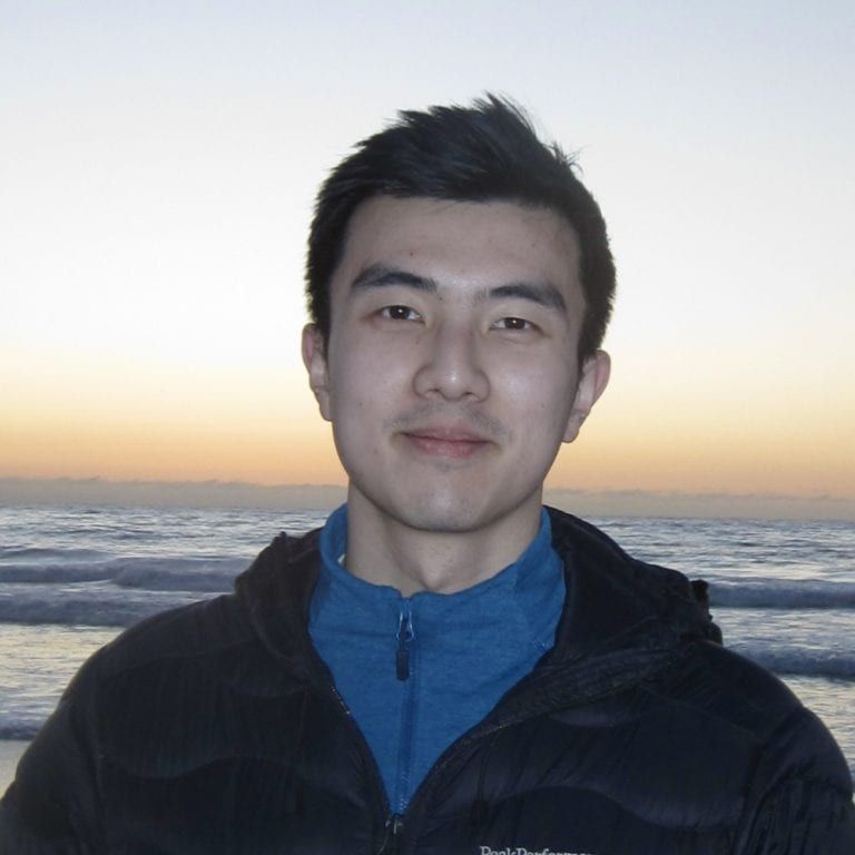 Headshot of a man in front of the ocean.