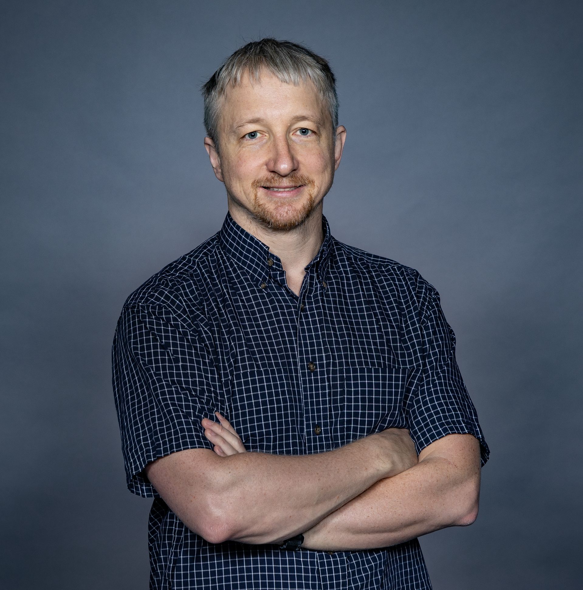 Alexey Gorshkov stands with his arms folded. 